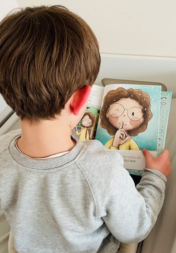 Das Bild zeigt einen kleinen Jungen von hinten, der unser Buch liest.